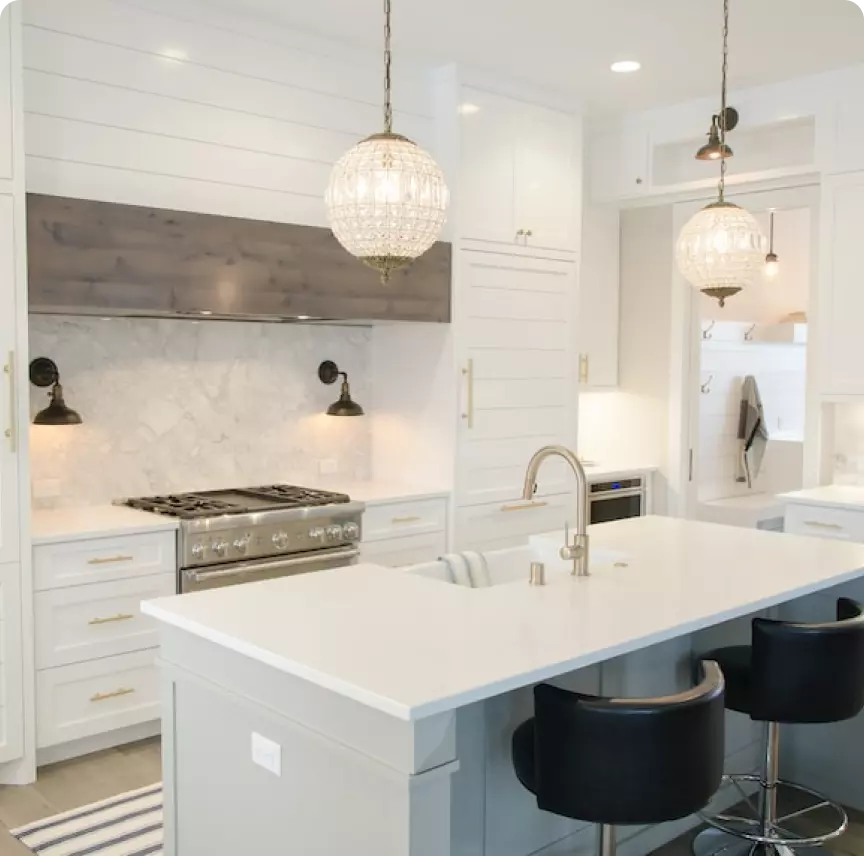 An elegant white kitchen with granite countertops and white cabinets